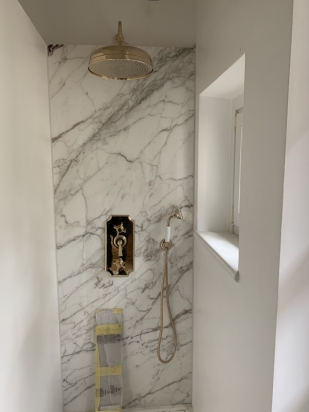 interno doccia con lastra in marmo,resina e piatto doccia tda, ribinetteria in oro